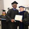 Kristy helping Dr. Gary present diplomas to students at the graduation. 